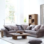 Фото 1: Серый угловой диван с подушками и деревянным столом