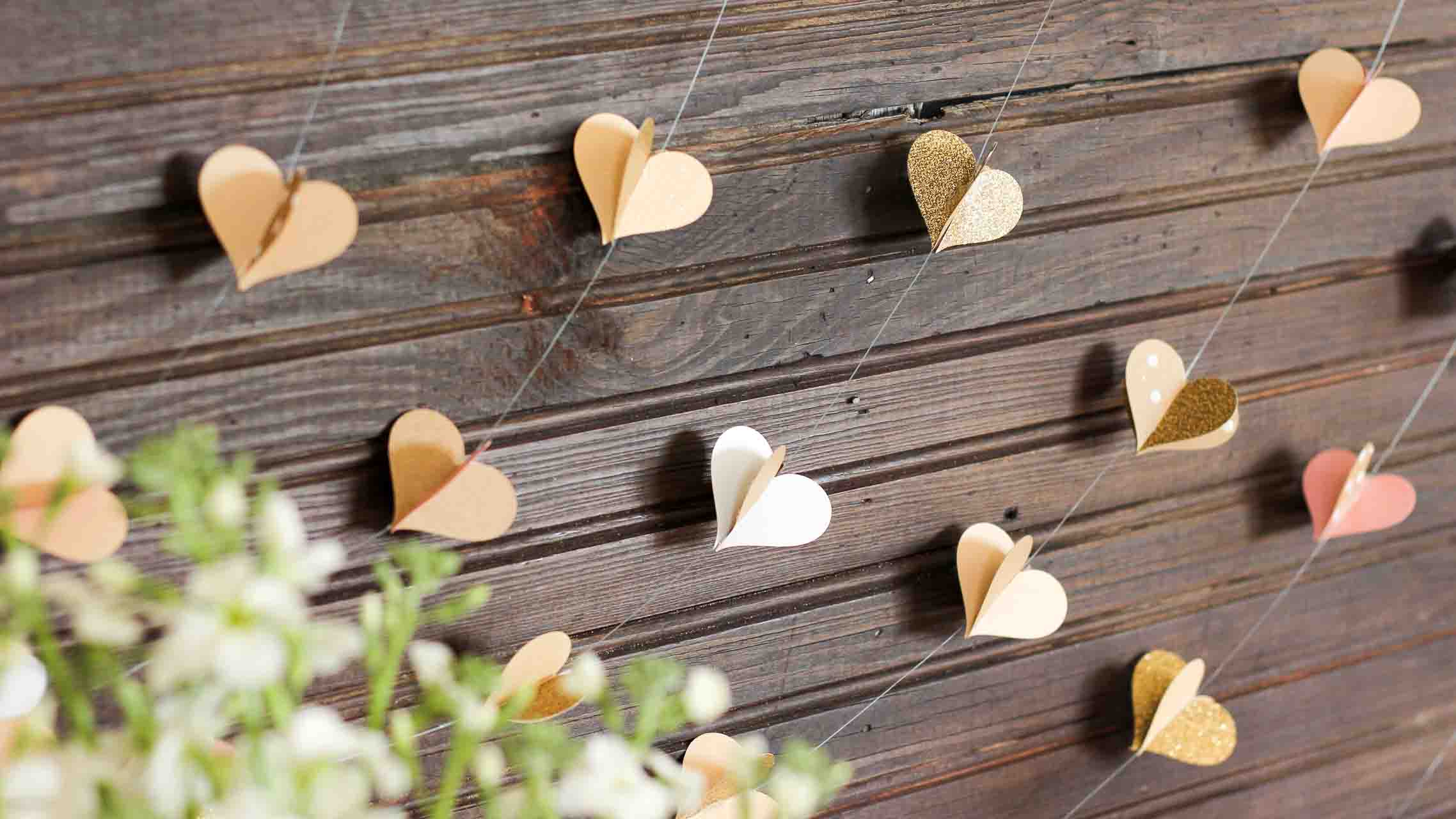 Гирлянду из сердечек можно с легкостью использовать не только для украшения зала на Новый год, но и при подготовке праздника ко Дню влюбленных, или на свадебное торжество